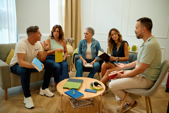 Group of friends discussing literature during book club meeting