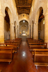 Obraz premium Church interior with wooden pews and stone arches in Monteriggioni