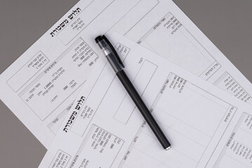 Israeli salary payslips (tlush maskoret in Hebrew) on desk, symbolizing payroll, income, taxes, and financial accounting concept.