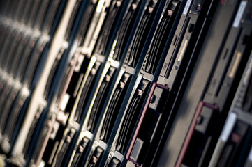 Close up of server hardware with hard drives stacked in rackmounted cabinet