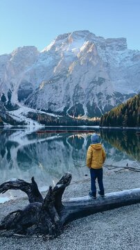 Child exploring Lago di Bries with stunning mountain backdrop in early morning light