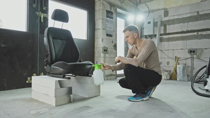 Man carefully cleans car seat. Spraying powerful cleaning solution on car seat, focused on removing dirt and stains. Transforming car seat with deep wash. Close-up in 4K, UHD