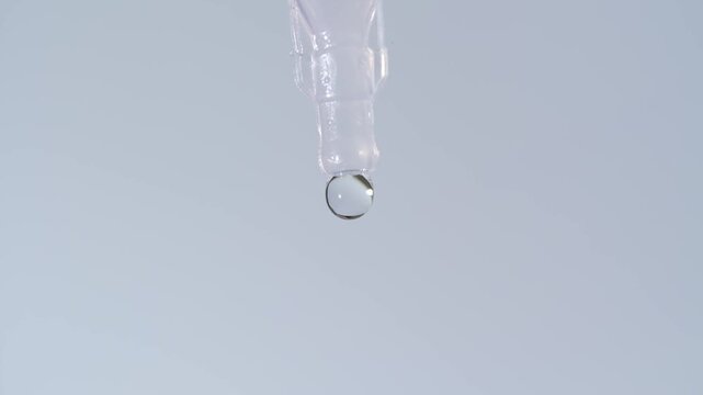 Close-up of a disposable eye drop vial administering a clear liquid solution into a person's open eye for hydration or medical treatment.