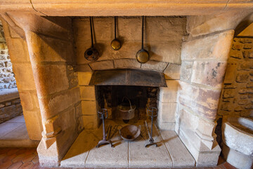Fototapeta premium Traditional stone fireplace with cooking utensils in Couches, FRANCE