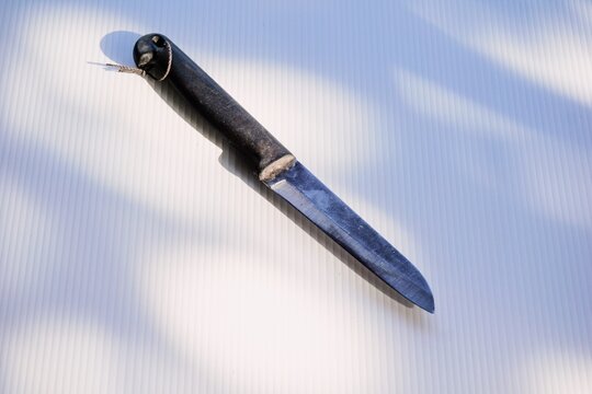 A well-worn utility knife placed diagonally on a bright white background