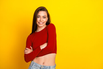 Young woman in red crop top smiles against bright yellow backdrop showcasing casual fashion style for lifestyle and shopping advertising