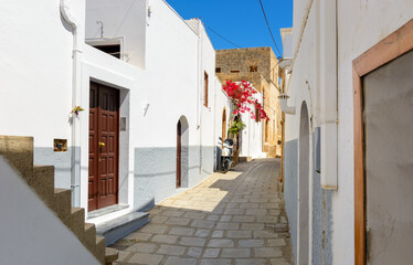 Cobblestone street with white houses on Rhodes island. Lindos village, Dodecanese, Greece.