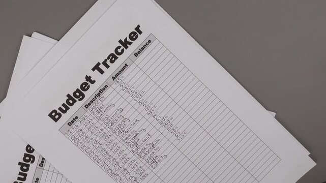 Open daily planner notebook on desk, with neatly handwritten organized Monthly Budget tracking table. With dates, categories and expenses. Personal finance management, spending and budgeting habits 