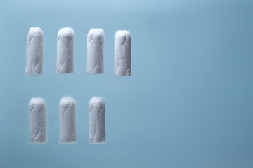 Feminine hygiene products, tampons floating on blue background for woman’s health, period care, medical advertising and personal wellness banner concepts 