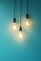 three glowing light bulbs suspended against a teal background