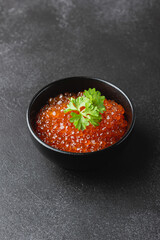 Red caviar with fresh parsley in bowl