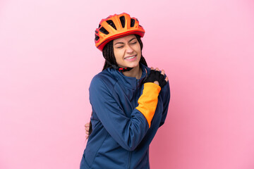 Teenager cyclist girl isolated on pink background suffering from pain in shoulder for having made an effort
