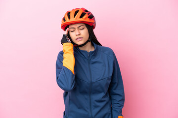 Teenager cyclist girl isolated on pink background with headache