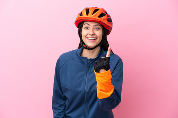 Teenager cyclist girl isolated on pink background doing coming gesture