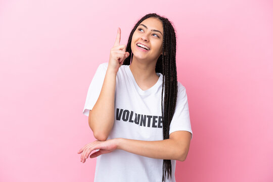 Teenager volunteer girl with braids isolated on pink background pointing up a great idea