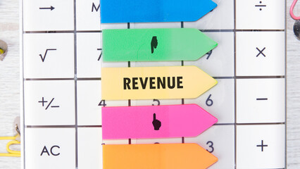 Brightly colored sticky markers highlight essential financial terms on a calculator, emphasizing the role of revenue in managing funds and making informed financial decisions