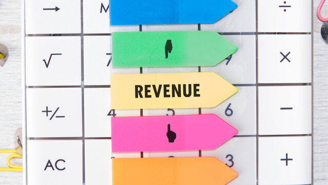 Brightly colored sticky markers highlight essential financial terms on a calculator, emphasizing the role of revenue in managing funds and making informed financial decisions