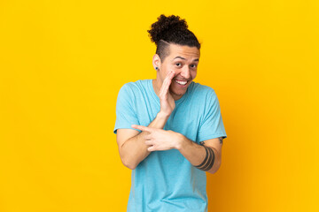 Caucasian man over isolated background pointing to the side to present a product and whispering...