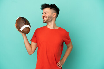 Young Caucasian man playing rugby isolated on blue background suffering from backache for having made an effort