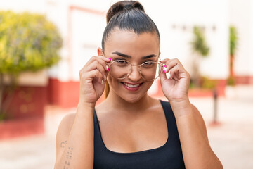 Young pretty woman at outdoors With glasses with happy expression