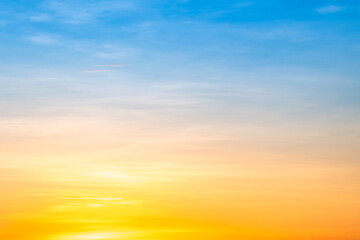 Obraz premium Sunset or sunrise sky with a vibrant gradient of orange, gold, and soft blue. Clear atmosphere with wispy clouds. Peaceful, natural light background. hope, freedom, new day and inspirational Concepts