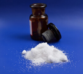 Thiourea powder on blue background.