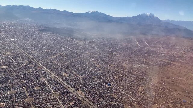 La Paz, Bolivia - June 02, 2025: Window view after take-off from El Alto International Airport SLLP. Snow covered mountains Mururata and Illimani on horizon.