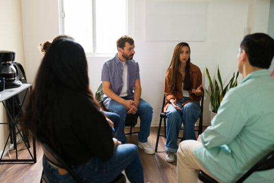 Sad looking people participating in support group therapy session