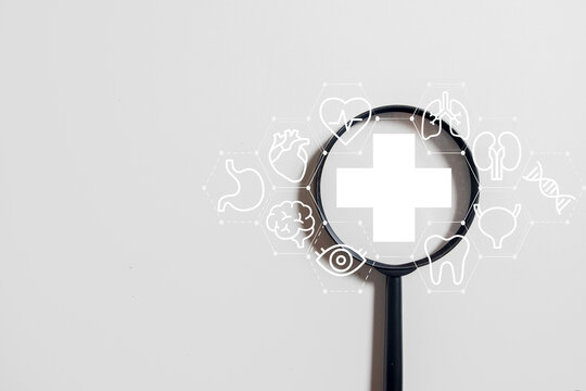 Magnifying glass focusing on a medical cross icon, analyzing a network of human organ icons. Concept for holistic health check-up, medical diagnosis, and research.,white background with copyspace.