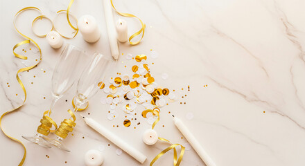 Two champagne glasses surrounded by colorful paper and candles create a festive atmosphere.