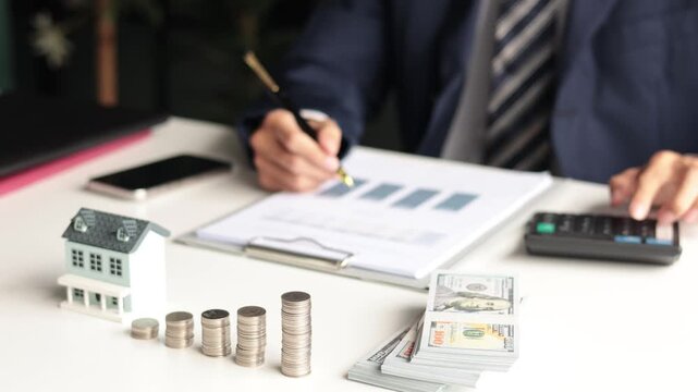 Investing in Real Estate, Real estate agent or investor calculating, planning, analyzing financial data for property investment. Themes of saving, investing, financial aspects of purchasing a home.