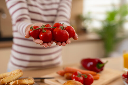 Woman offering fresh ripe tomatoes for healthy cooking