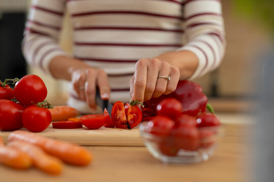 Woman chopping fresh vegetables preparing healthy meal in kitchen