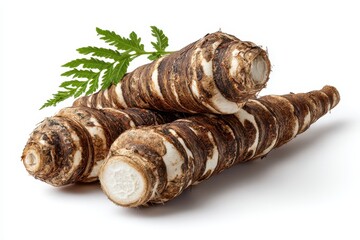 Three taro roots are piled up with a fern on a white surface. Showcase exotic foods or ingredients for culinary content.