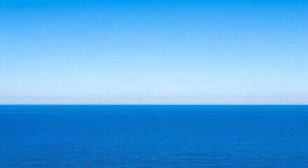 Obraz premium Vast expanse of the deep blue sea meeting the clear blue sky above it