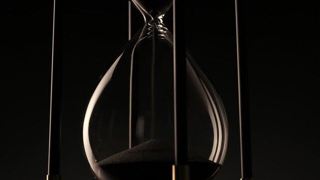 conceptual image of a rotating hourglass in low light, symbolizing eternity, change, and the fragile beauty of every second.