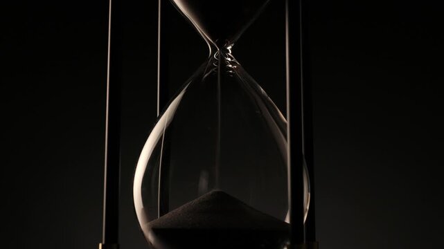 elegant hourglass with sand in motion, a poetic symbol of patience, transition, and the irreversible passing of time