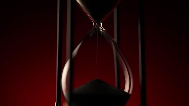 elegant hourglass with sand in motion, a symbol of  the irreversible passing of time