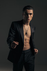 Obraz premium sexy young man in tuxedo with no shirt looking forward and posing