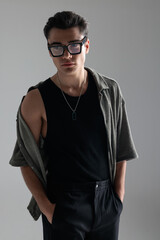 Fototapeta premium sexy casual man with glasses holding hands in pockets and looking away