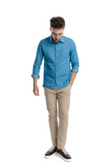 Fototapeta premium Casual man standing with hand in pocket looking down