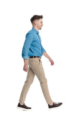 Naklejka premium Side view of casual man with glasses walking