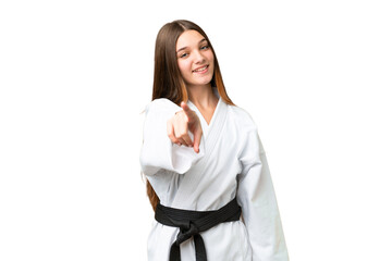 Teenager girl doing karate over isolated chroma key background pointing front with happy expression