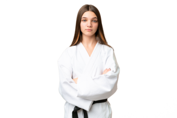 Teenager girl over isolated chroma key background doing karate keeping the arms crossed