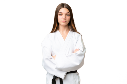 Teenager girl over isolated chroma key background doing karate keeping the arms crossed