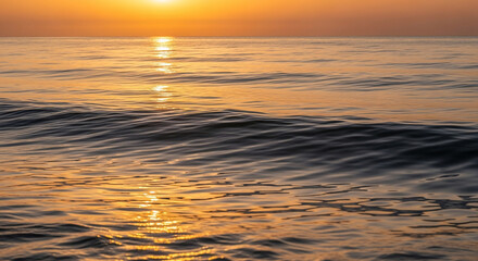 Obraz premium Golden hour bathes the tranquil ocean waves in a warm, serene light