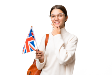 Teenager student caucasian girl holding an United Kingdom flag over isolated background happy and smiling