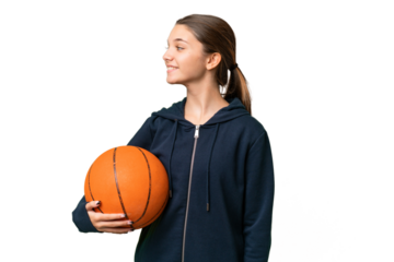 Teenager caucasian girl playing basketball over isolated background looking side