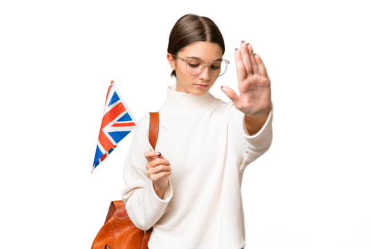 Teenager student caucasian girl holding an United Kingdom flag over isolated background making stop gesture and disappointed
