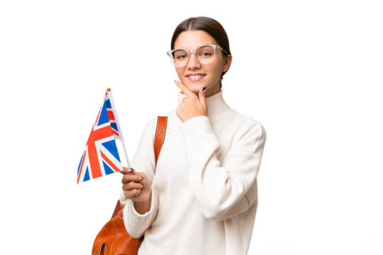 Teenager student caucasian girl holding an United Kingdom flag over isolated background happy and smiling